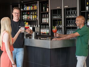 A bar area with a counter, shelves with bottles, and glasses. - ibis Lyon Caluire Cité Internationale (Caluire-et-Cuire)