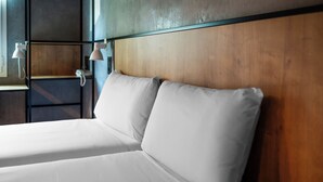 A hotel room with a wooden headboard, two white beds, and bedside lamps. - ibis Barcelona Montmelo-Granollers (Granollers)