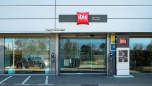 A modern hotel entrance with a glass facade, a red logo, and a sign indicating it's in Barcelona. - ibis Barcelona Montmelo-Granollers (Granollers)