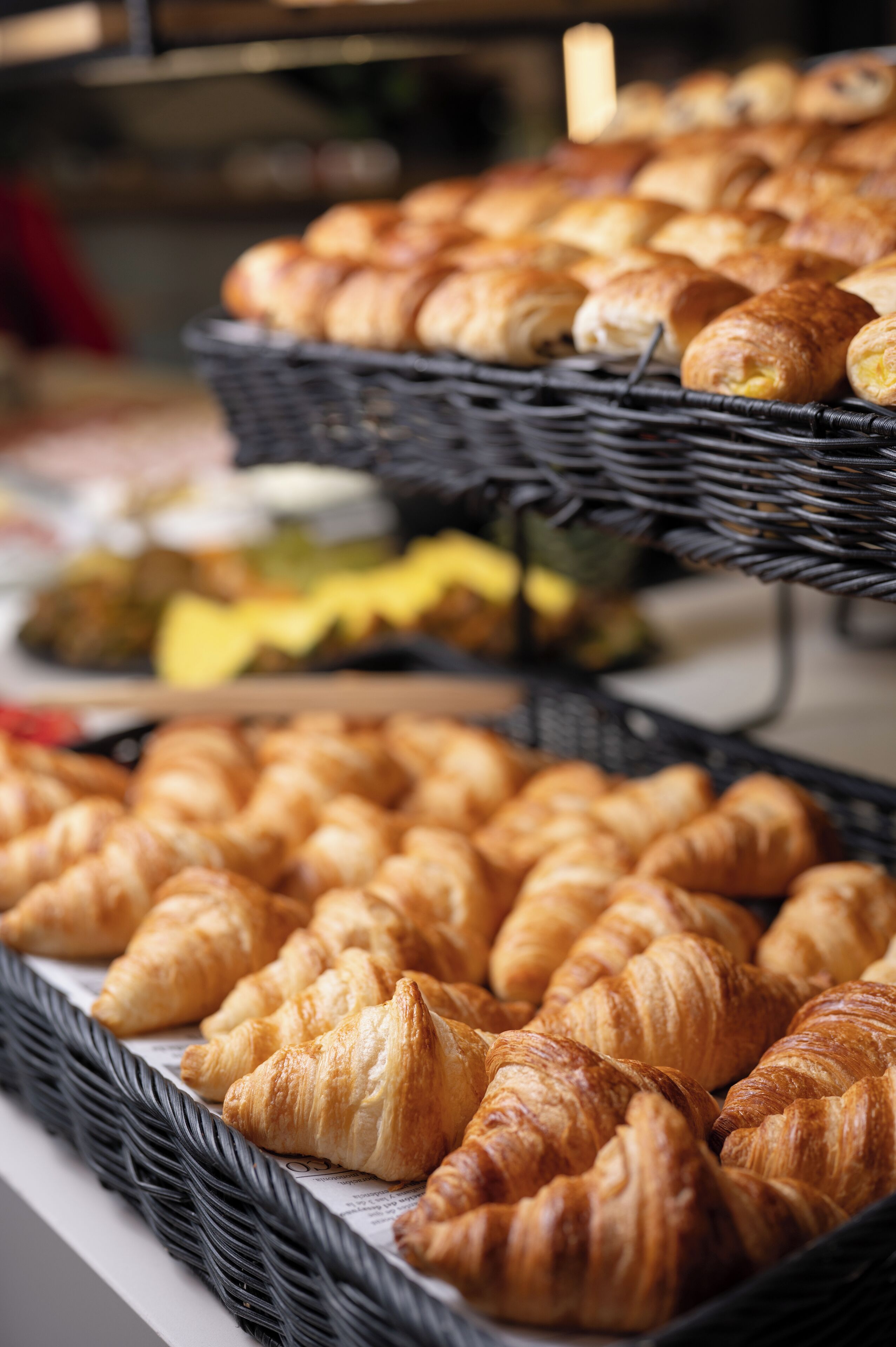 A display of assorted baked goods, including croissants and other pastries, arranged on trays.