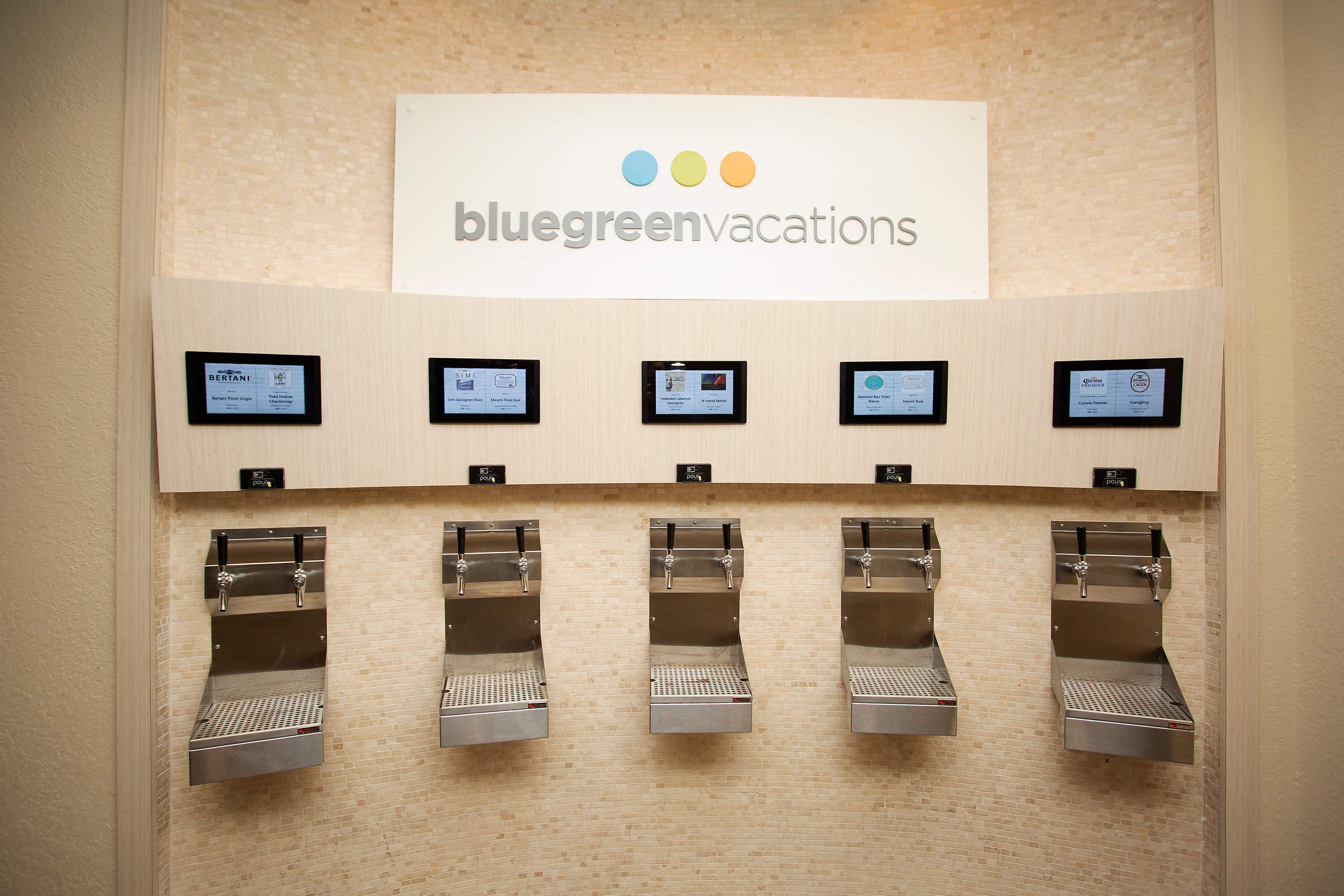 Letrero de BlueGreen Vacations sobre una fila de máquinas expendedoras de café.