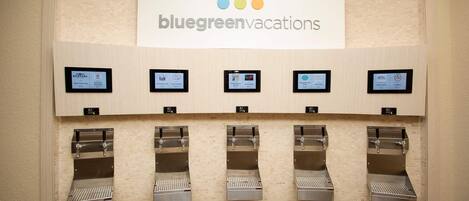 Letrero de BlueGreen Vacations sobre una fila de máquinas expendedoras de café.