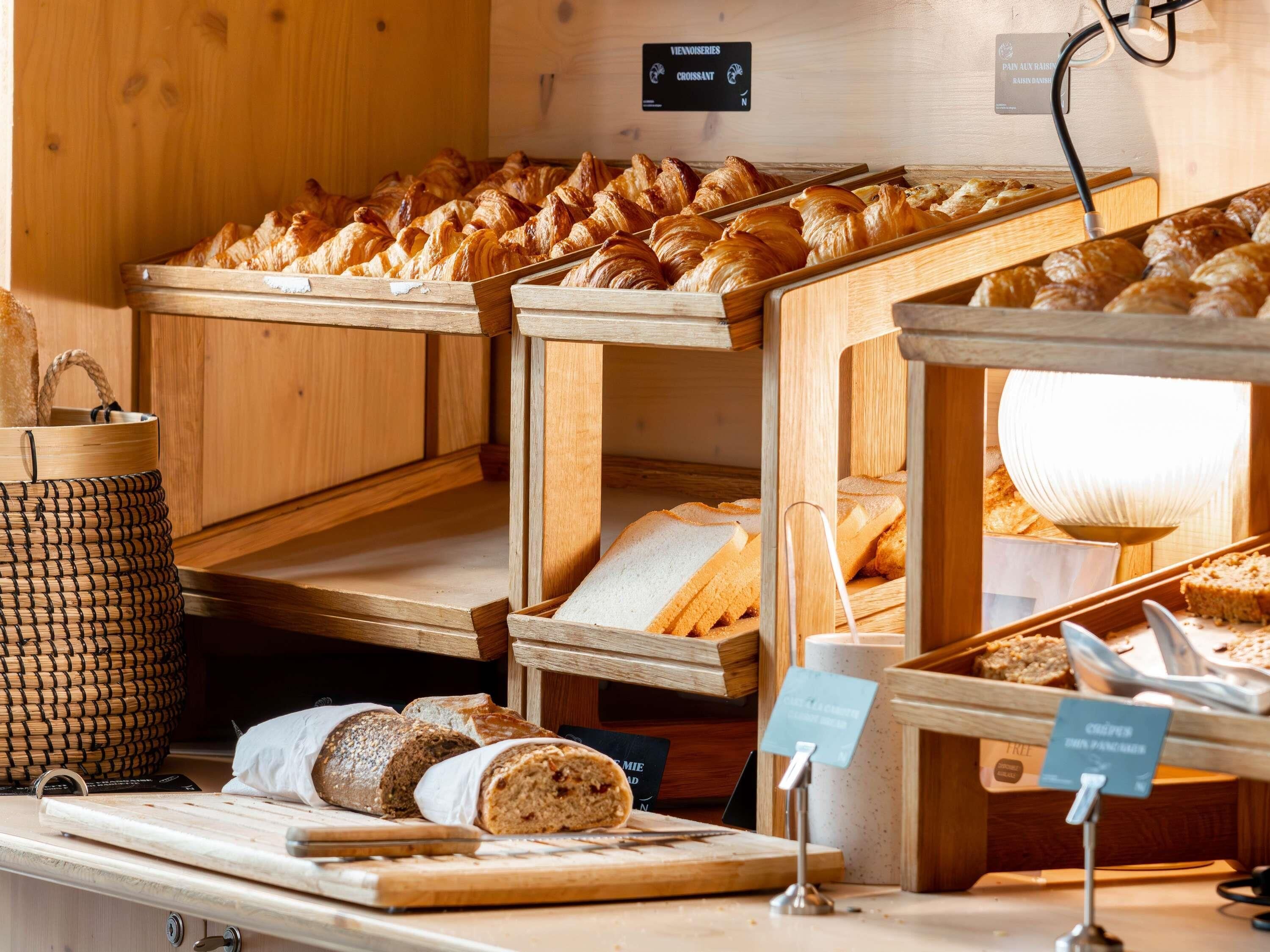 Une vitrine de boulangerie présentant une variété de pains et de pâtisseries.