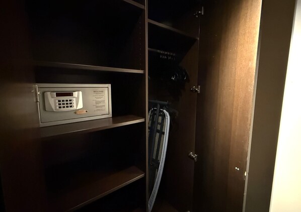 A dark wooden cabinet with a built-in safe and a bicycle rack. - Hotel Lumière an der Messe by ANS (Frankfurt)