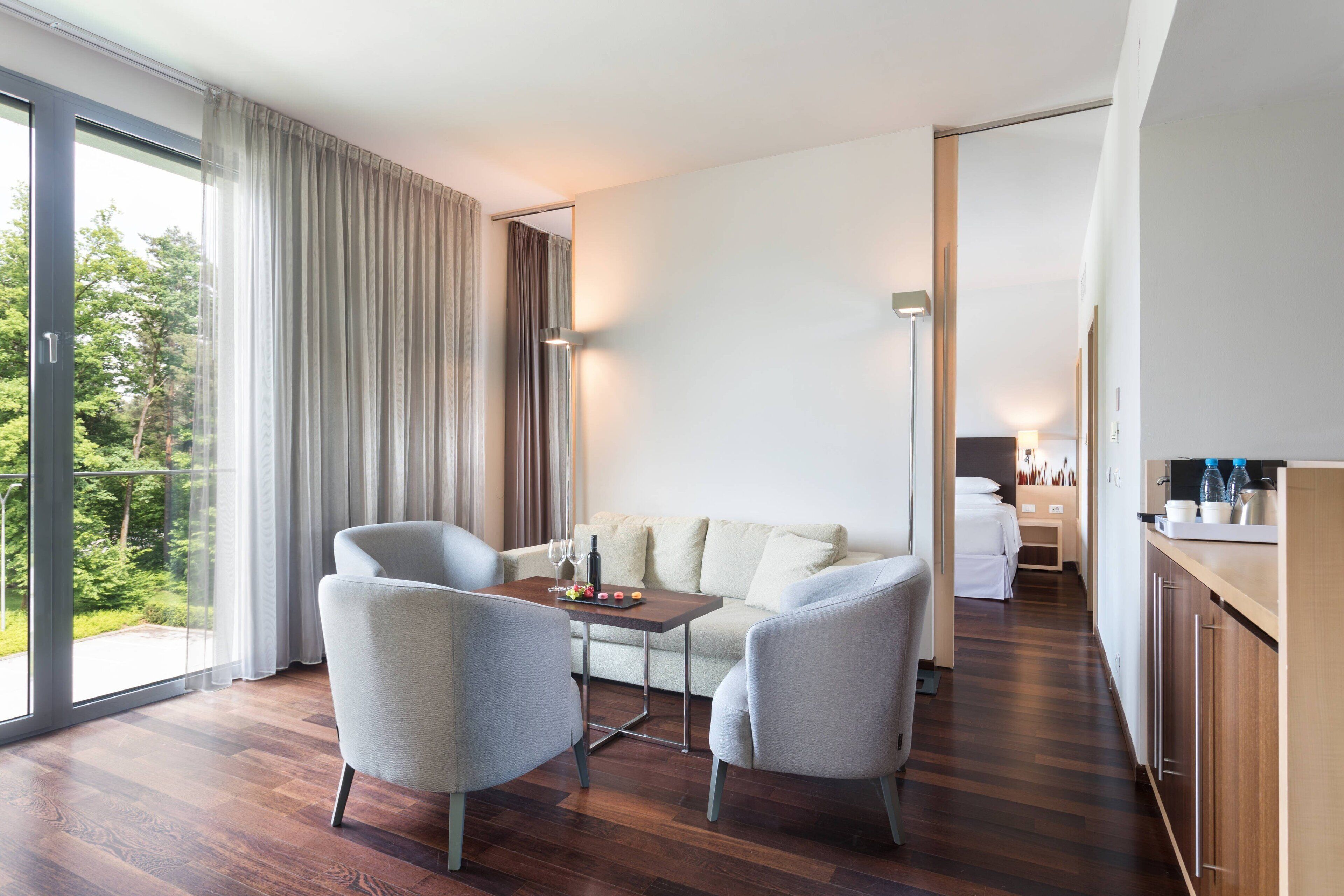 Une chambre d’hôtel moderne dotée d’un coin repas, d’un canapé et d’un comptoir de cuisine.
