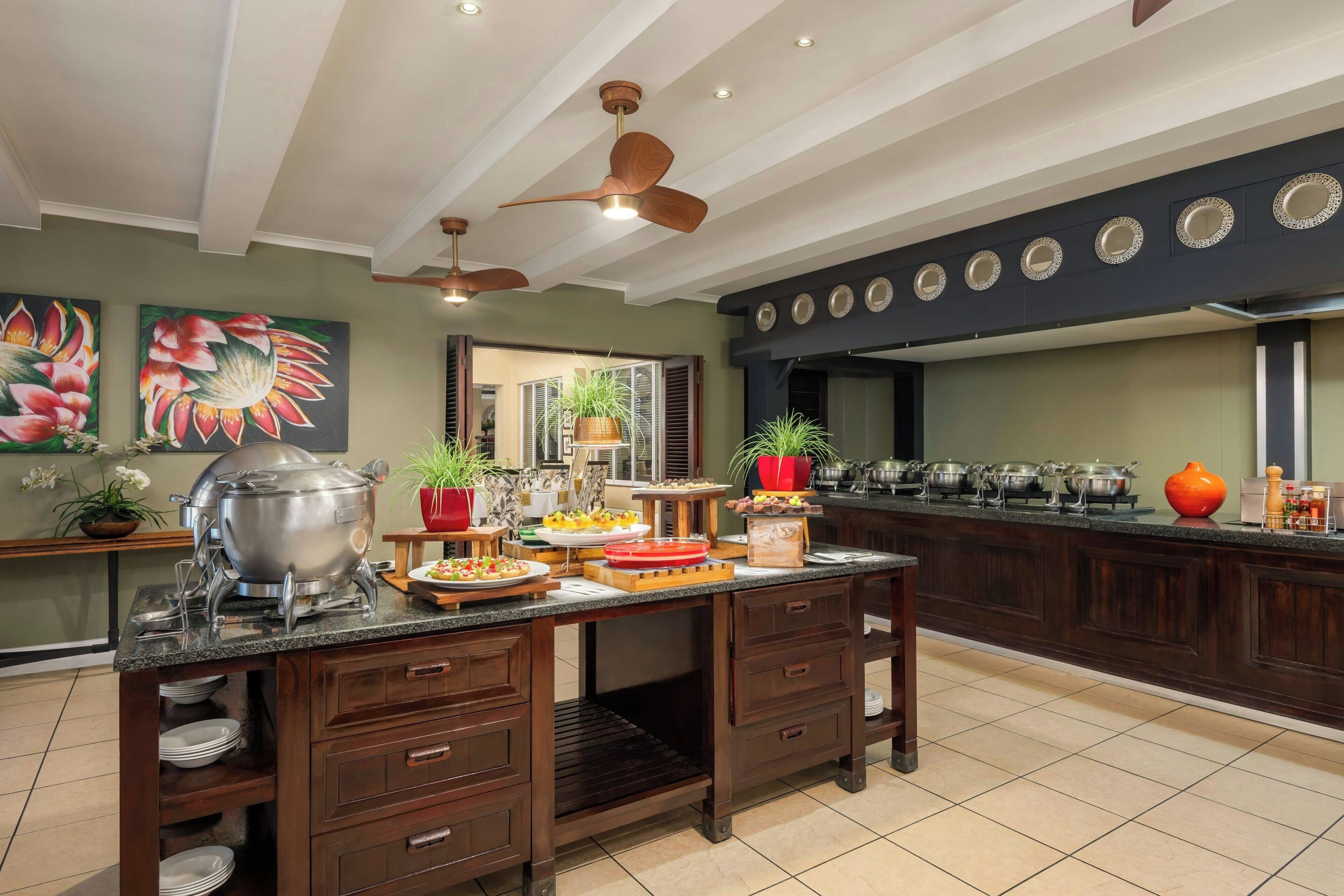 Una cocina con distribución tipo bufé, armarios de madera y ventiladores de techo.
