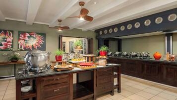 Una cocina con distribución tipo bufé, armarios de madera y ventiladores de techo.