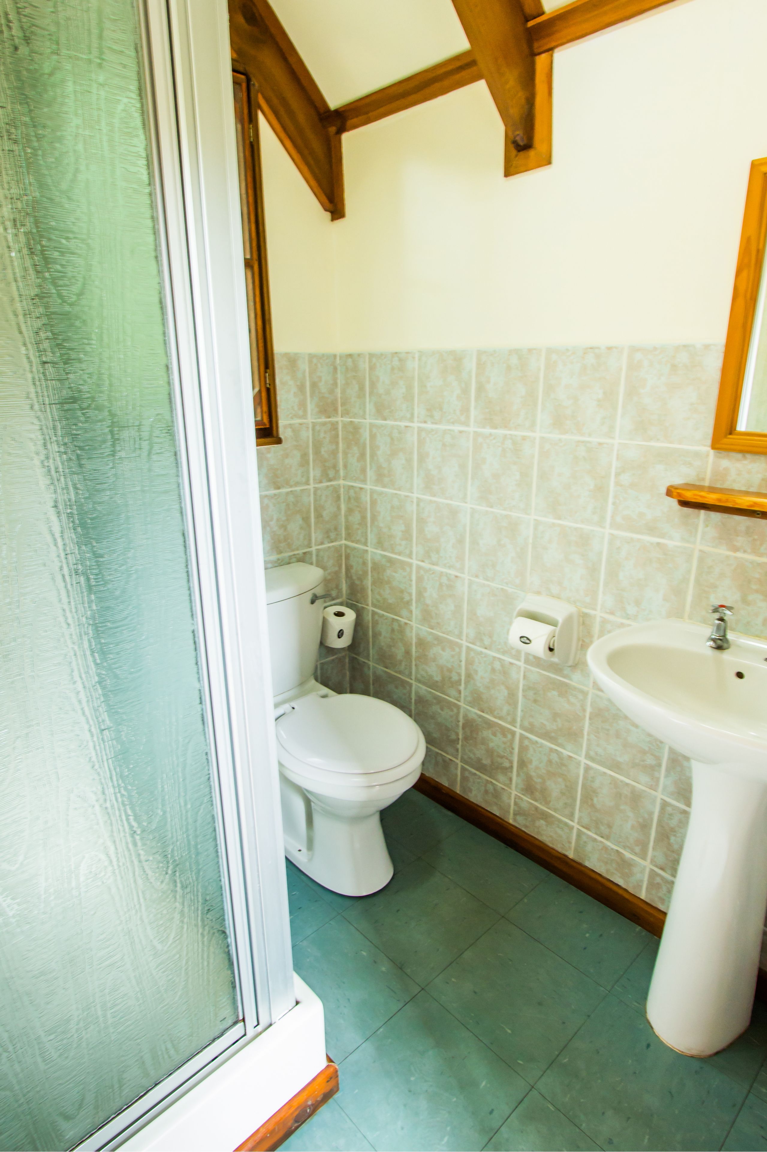 A bathroom with a toilet, sink, and tiled walls.