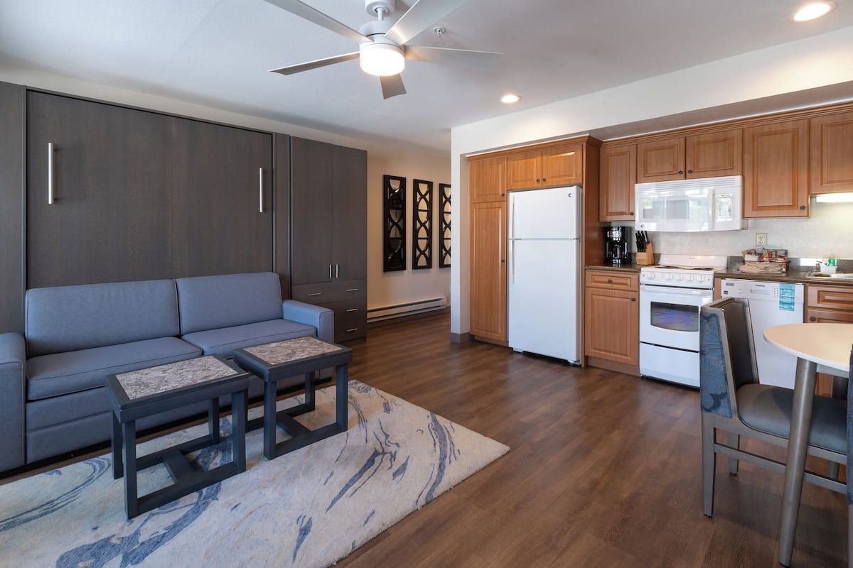 A modern kitchen with wooden cabinets, a built-in microwave, and a refrigerator.
