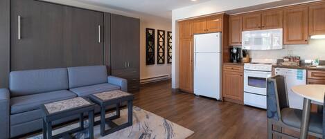 A modern kitchen with wooden cabinets, a built-in microwave, and a refrigerator.