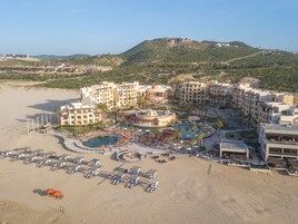 Un resort con varias edificaciones, una zona de piscina y una playa.