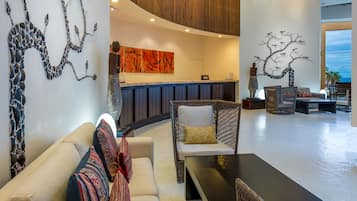 A modern lobby with a reception desk, seating area, and artwork on the walls.