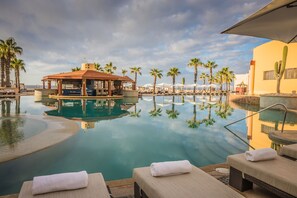A resort pool area with lounge chairs, a cabana, and palm trees. - Pueblo Bonito Pacifica Golf & Spa Resort -All Inclusive-Adult Only (Cabo San Lucas)