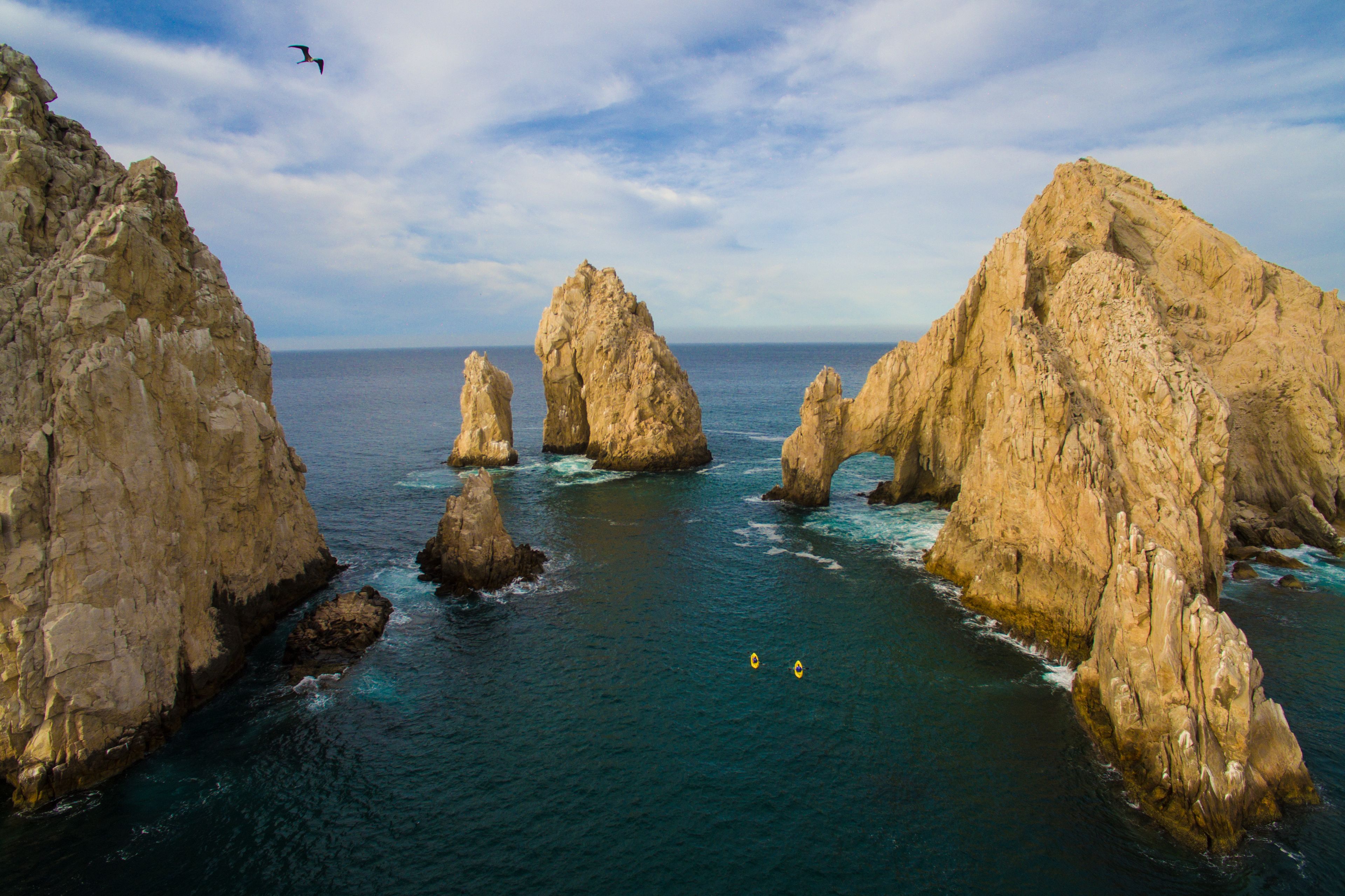 A coastal landscape with prominent rock formations and a clear view of the sea.
