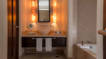 A bathroom with a marble sink, a mirror, a towel rack, and a bathtub.