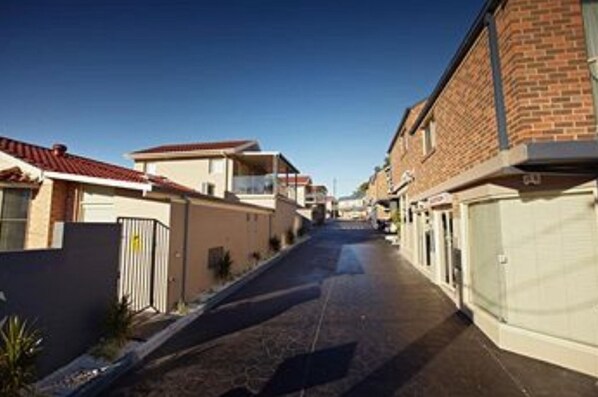 A residential street with houses on both sides, a clear sky, and a paved road. - Jesmond Executive Villas (Jesmond)