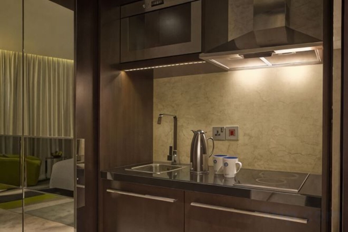A modern kitchen with a built-in stove, a coffee maker, and a kettle.