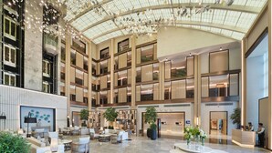 A spacious lobby with multiple seating areas, a reception desk, and a high ceiling with decorative lighting. - Al Ain Rotana (Al Ain)