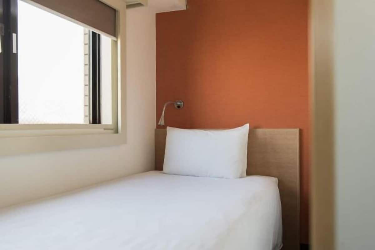 Escritorio, cortinas blackout y tabla de planchar con plancha