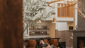 A cozy living area with a sofa, a fireplace, and a wine rack. - Chalet View Lodge (Portola)