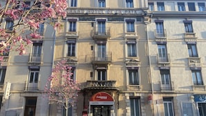 A multi-story hotel with balconies, a central entrance, and signage for 'The Originals Boutique Hotel Terminus'.