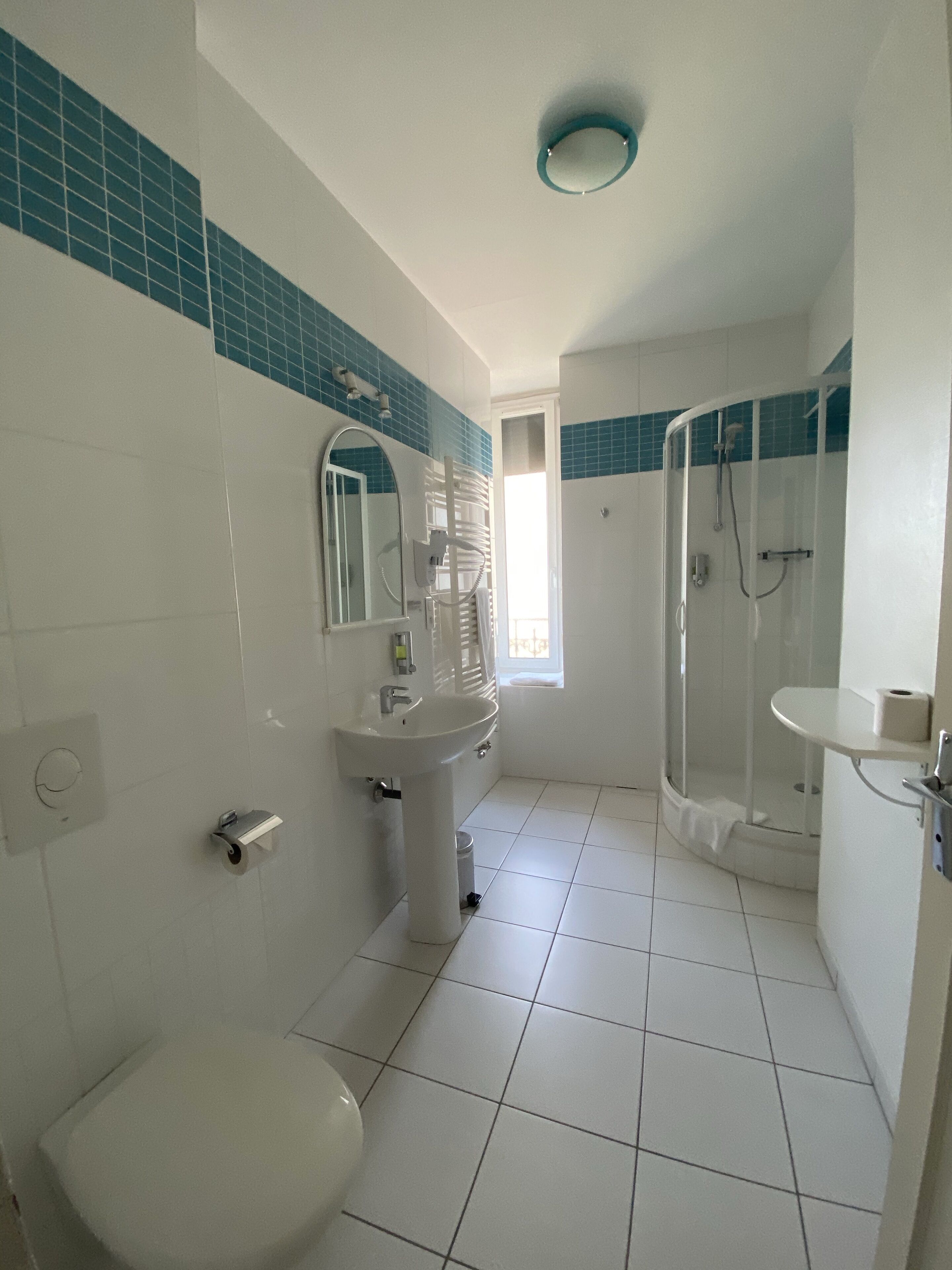 Un baño con inodoro, lavamanos y zona de ducha.