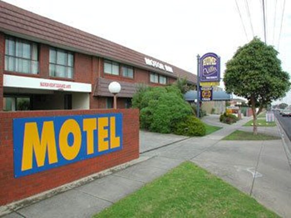 Un motel con un letrero grande que dice 'Motel', un estacionamiento visible y un cartel que indica 'The Inn at 2nd Street'.
