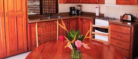 A spacious kitchen with wooden cabinets, a central island, and a hanging light fixture.