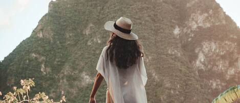 A person walking on a wooden deck with a mountainous backdrop.