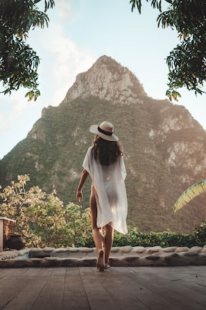 A person walking on a wooden deck with a mountainous backdrop. - Stonefield Villa Resort (Soufrière)