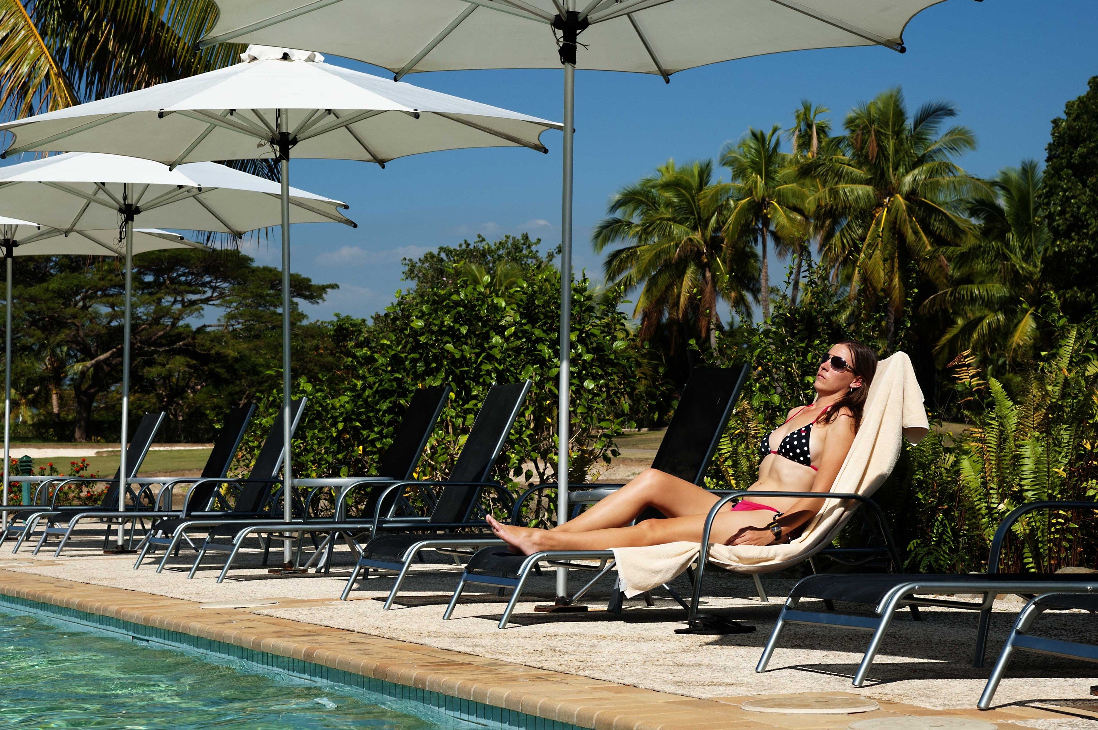 A poolside area with lounge chairs and umbrellas.