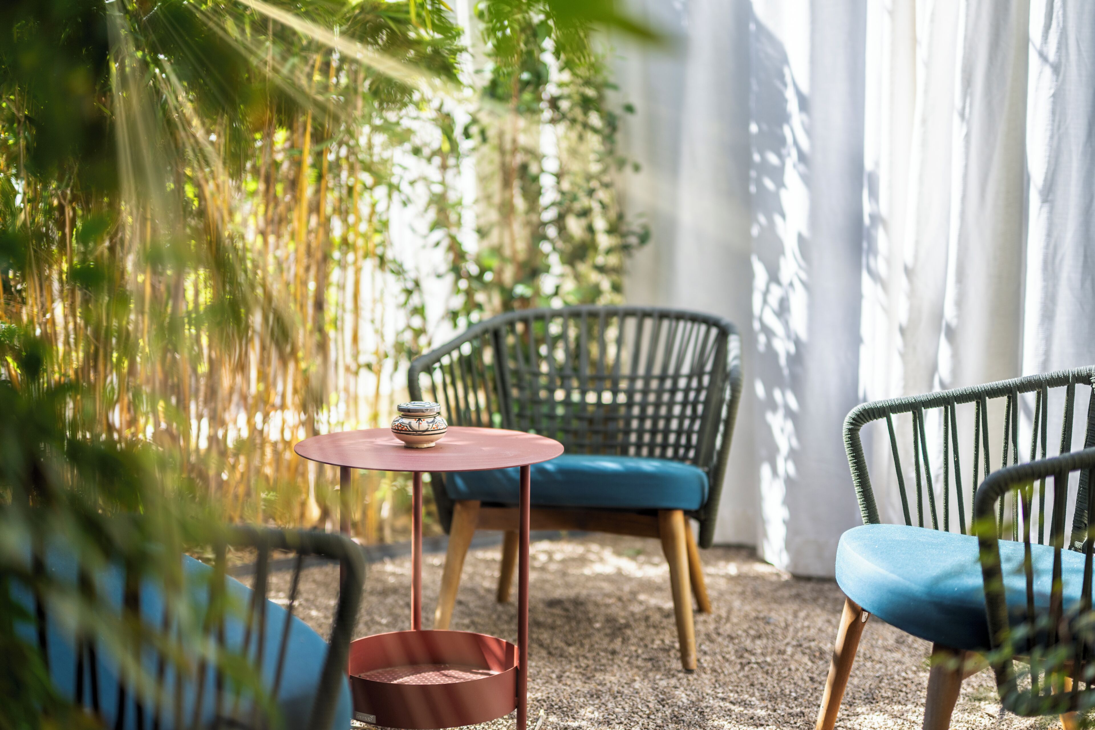 A patio area with wicker chairs, a small round table, and a decorative bowl.