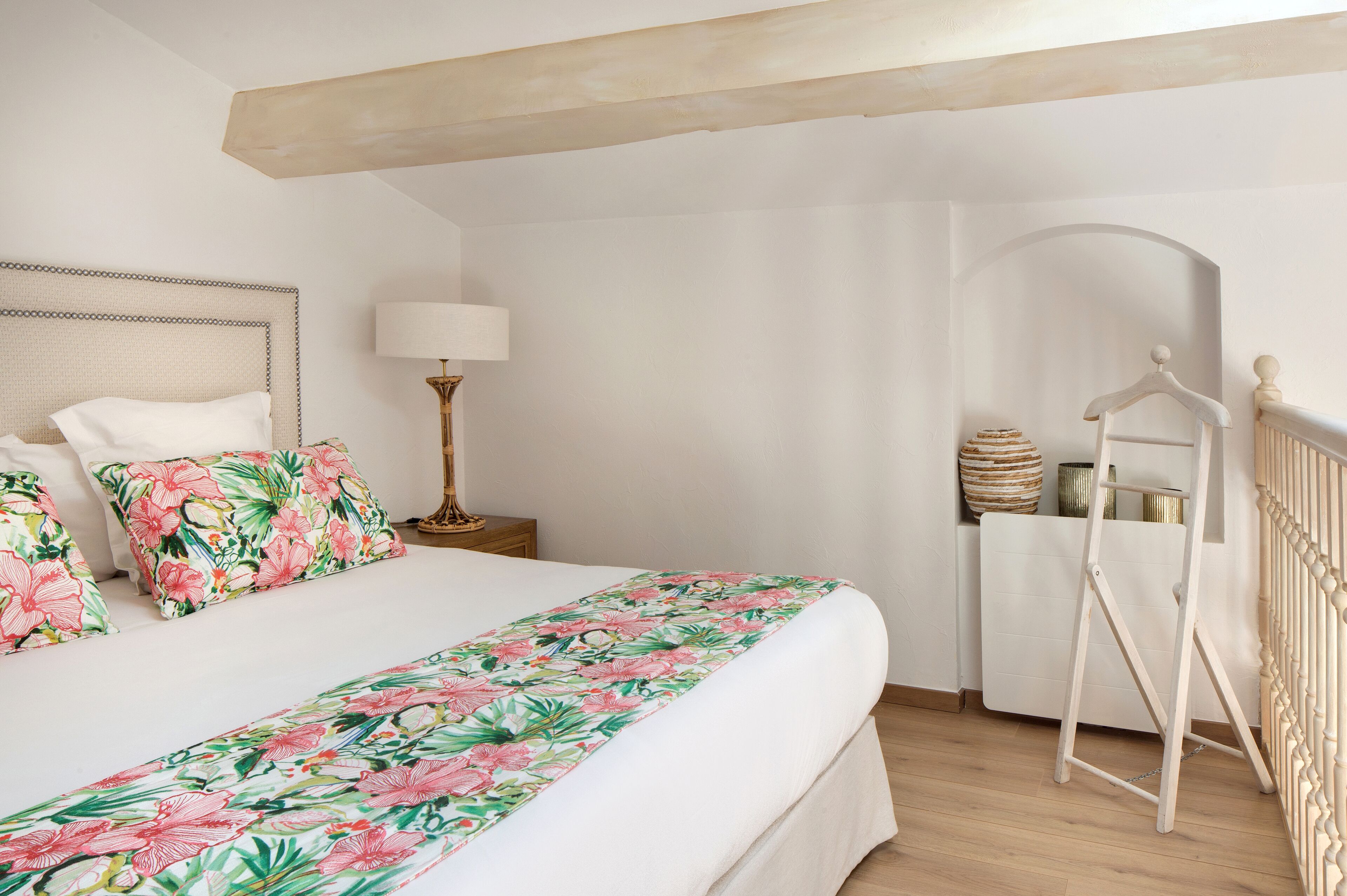 Une chambre à coucher comprenant un lit, une table de chevet, une lampe, une commode et un radiateur.