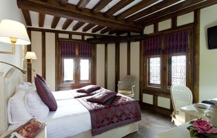 Un dormitorio con cama, dos sillas, escritorio y ventana con vistas.