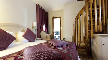 A hotel room with a large bed, a wooden staircase, and a view of the outside.