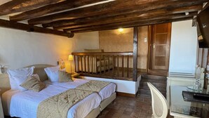 A bedroom with a bed, bedside table, and a chair. There is a wooden ceiling and a tiled floor. - Auberge Saint-Pierre (Le Mont-Saint-Michel)