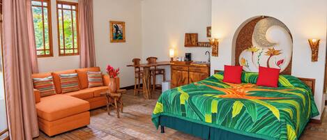 A room with a bed, a sofa, a desk, and a dining table.