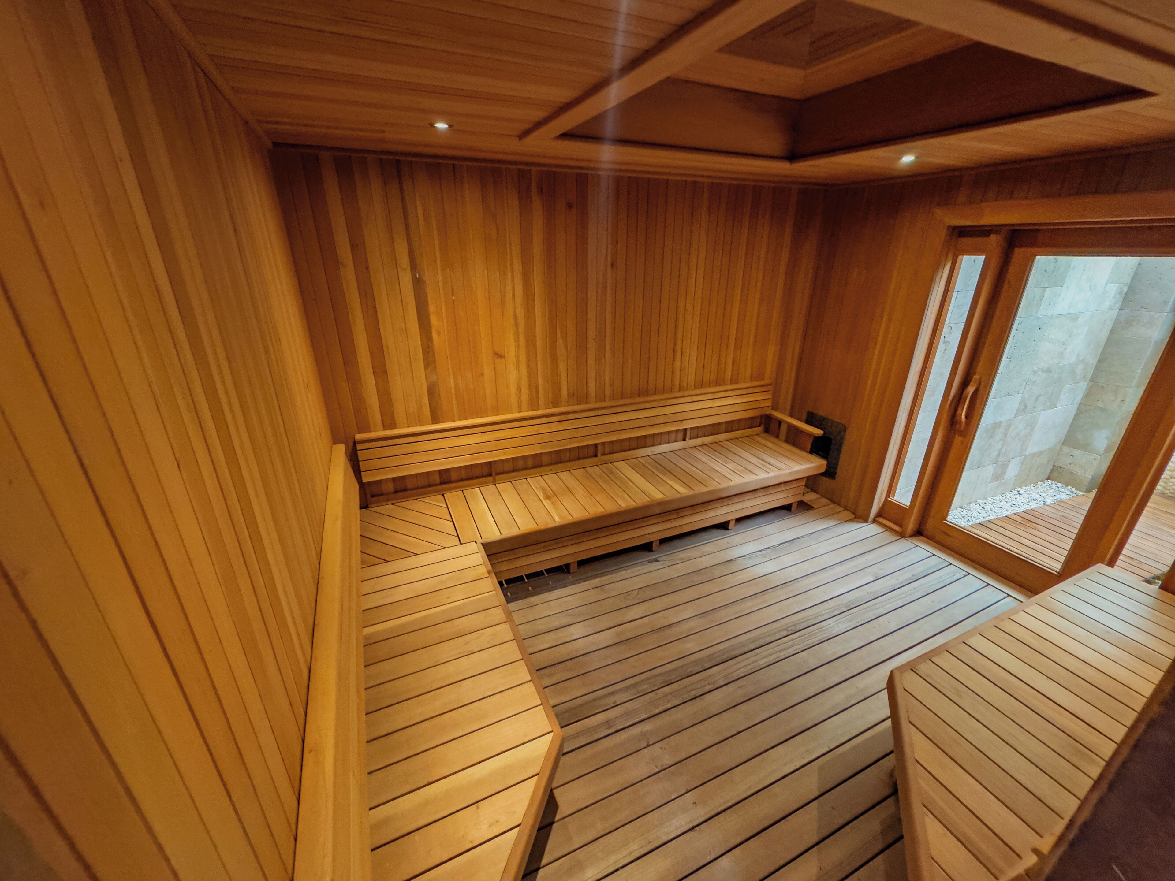 Una sauna de madera con bancos y piso inclinado.