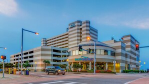 A hotel with a modern design, featuring a prominent 'Beach Quarters' sign, a parking garage, and a street intersection with traffic lights. - Beach Quarters Resort (Virginia Beach)