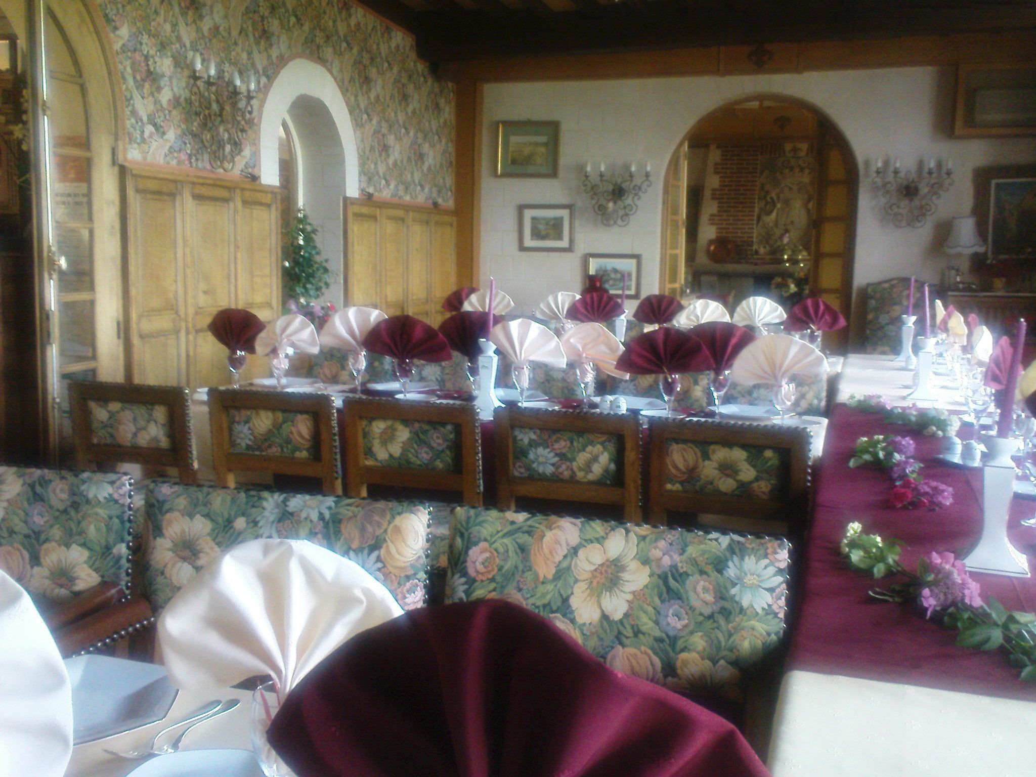 A dining area with floral-patterned chairs and tables set for a meal.