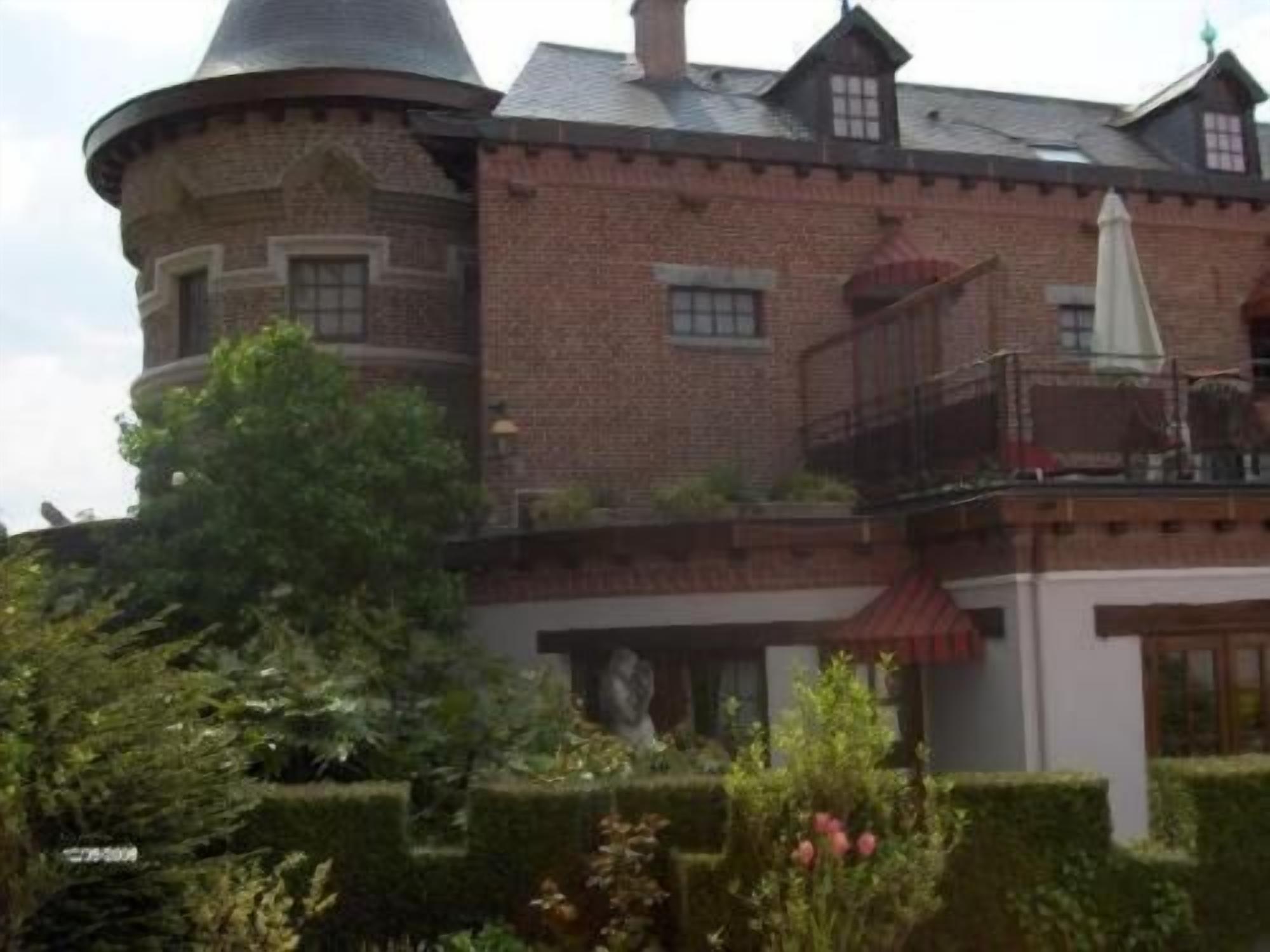 A large, historic building with a round tower and a balcony.