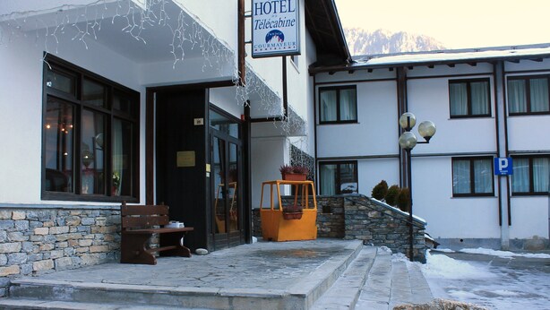 A hotel entrance with stone steps, a bench, and a sign indicating a Courtyard Mont Blanc. - Hotel de la Telecabine (Courmayeur)