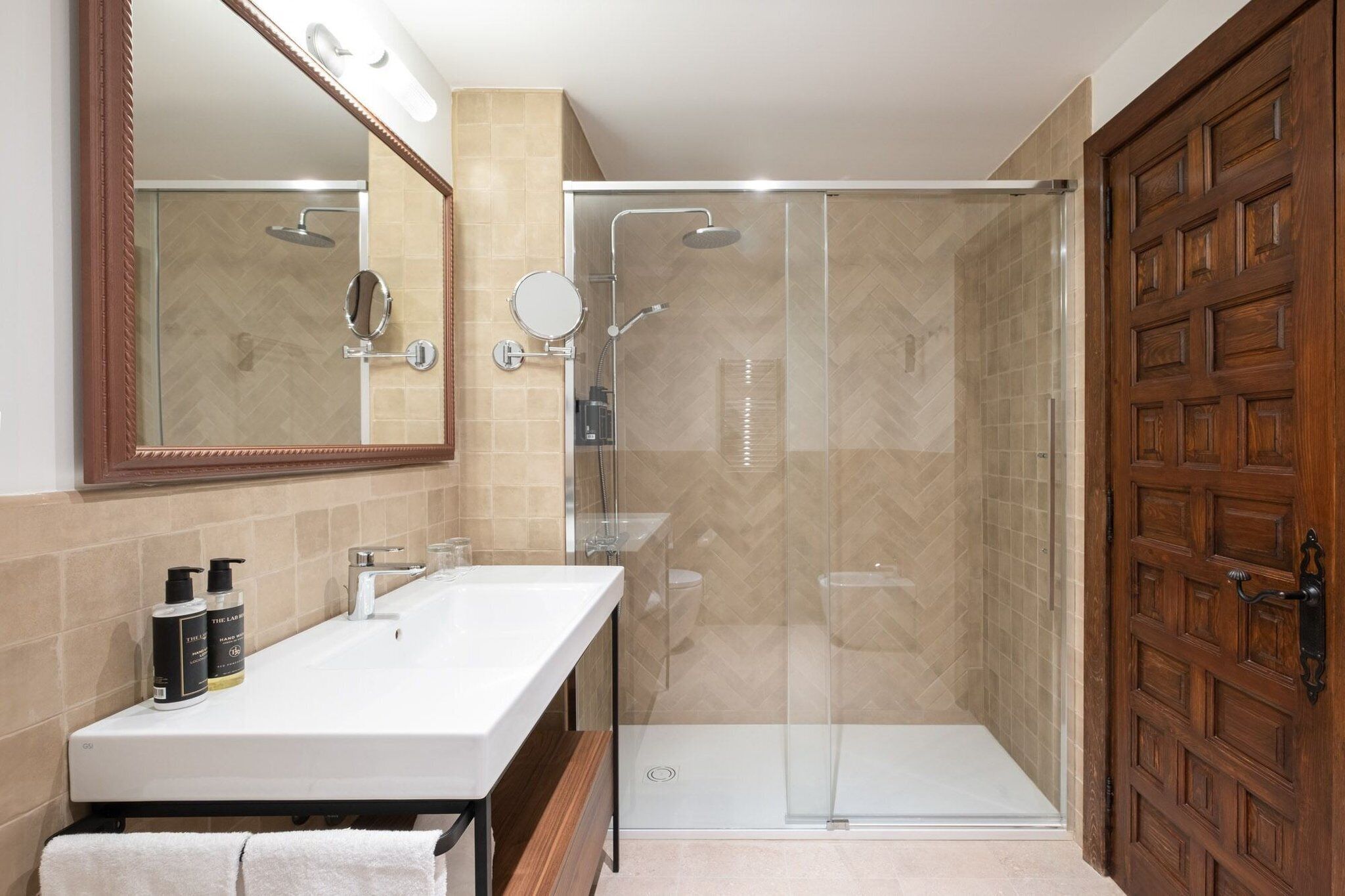 A bathroom with a shower, a sink, and a mirror.