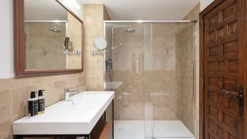 A bathroom with a shower, a sink, and a mirror.
