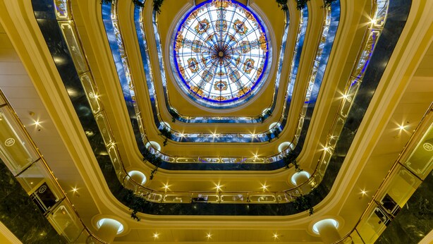 A multi-level atrium with a central stained glass dome, multiple balconies, and a marble floor. - Hotel Infanta Cristina (Jaén)