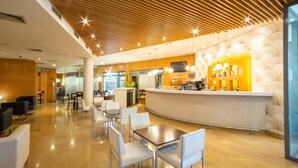 A modern lobby with a curved reception desk, white chairs, and a polished floor.