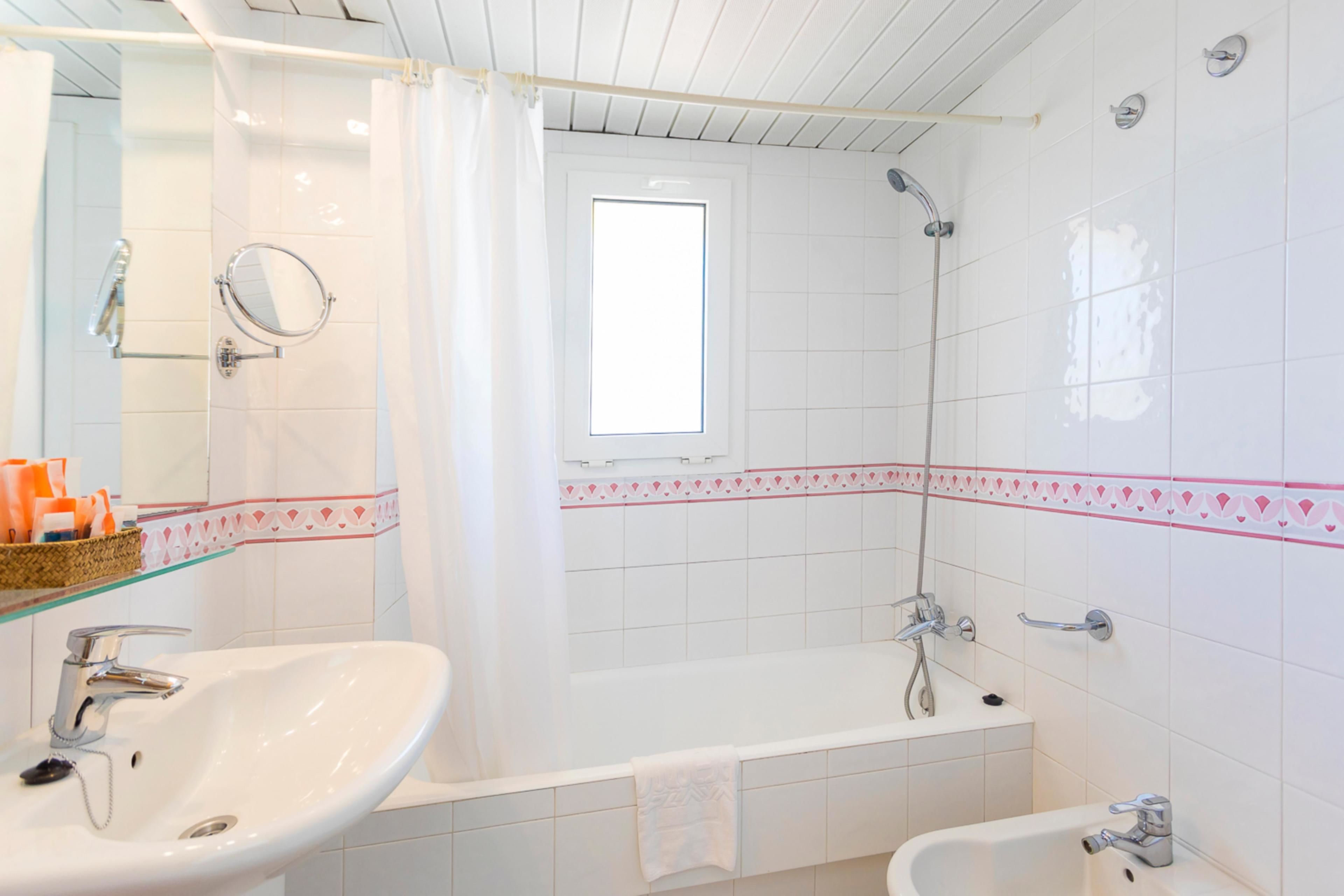 A bathroom with a white sink, a bathtub, and a shower.