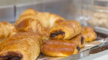 Una bandeja de metal con pasteles, incluyendo croissants y hojaldres rellenos de chocolate.