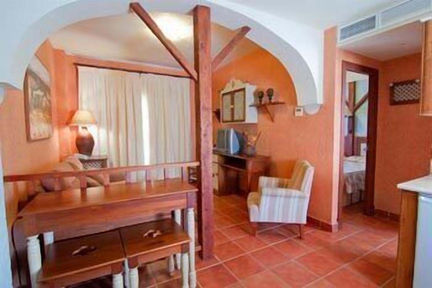 Un espace de vie compact comprenant un coin repas, une kitchenette et un petit coin salon.
