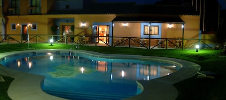 Una piscina al aire libre de temporada, sillones reclinables de piscina